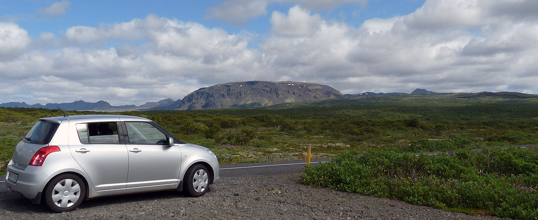 Mietwagen vor Bergkulisse in Island