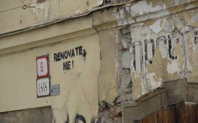 "Renovate me"-Spruch an altem Haus