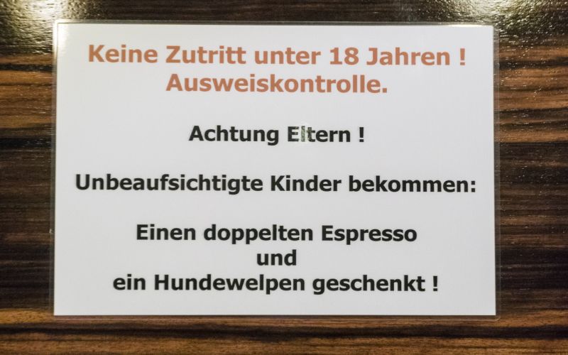 Schild mit "Unbeaufsichtigte Kinder bekommen einen doppelten Espresso und einen Hundewelpen geschenkt"