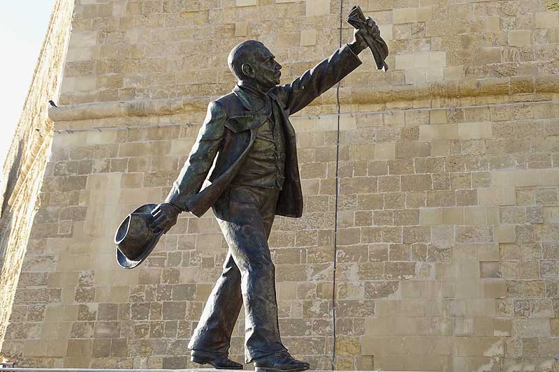 Statue von Mann mit Hut und Zeitung