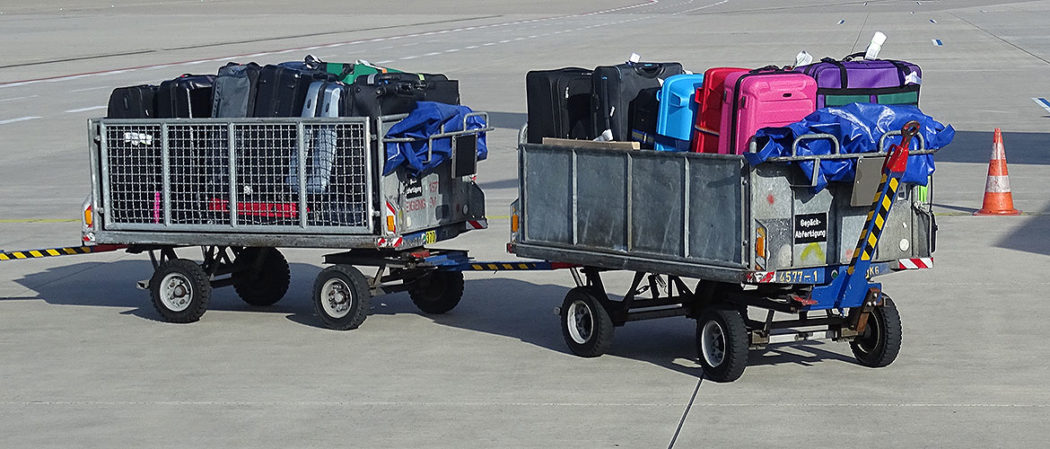 Gepäckwagen mit Koffern am Flughafen
