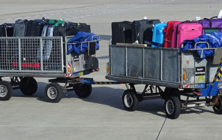 Gepäckwagen mit Koffern am Flughafen