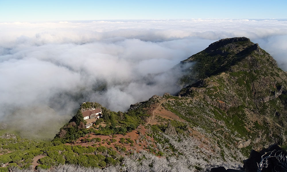 Blick vom Gipfel des Pico Ruivo auf Haus, Berg und Wolken