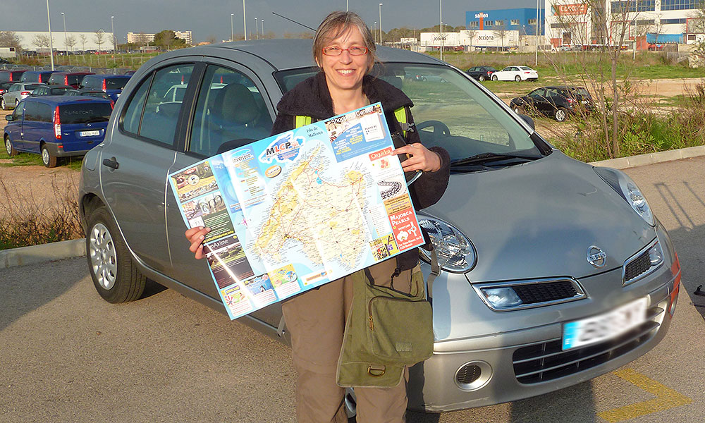 Frau vor Mietwagen mit Mallorca-Karte