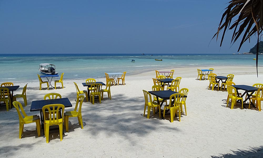 Gelbe Plastikstühle am Strand von Perhentian Besar