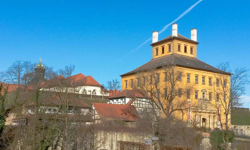 Gelbes Haus vor Fachwerkhäusern