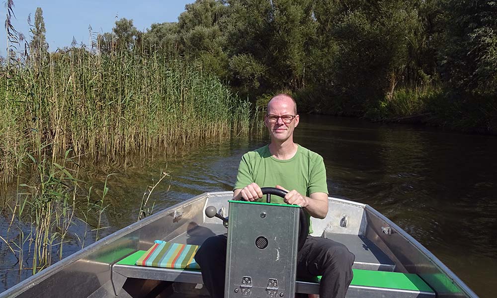 Mann am Lenkrad eines Bootes