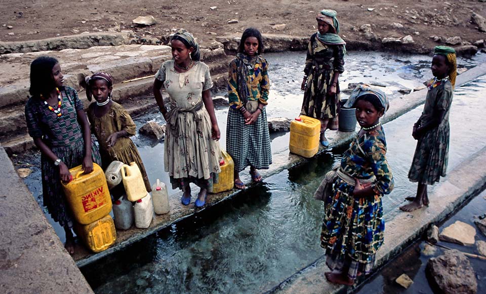 Afrikanische Kinder an einer Wasserstelle