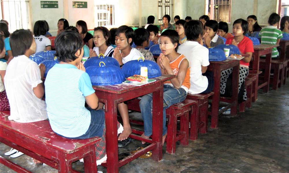 Asiatische Kinder am Tisch vor dem Essen