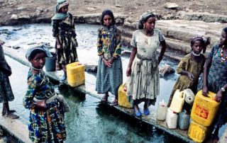 Frauen und Mädchen in Äthiopien holen Wasser an sauberer Wasserstelle