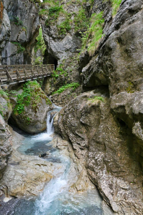 Holzsteg über einen Wasserfall bei der Klammwanderung in Tirol