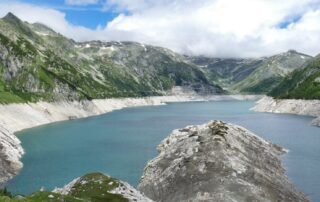 Blick auf Stausee mit Bergen rechts und links