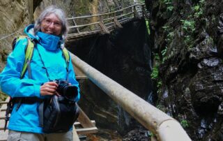 Frau mit Kamera in einer Klamm