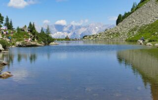 See mit Bergmassiv im Hintergrund