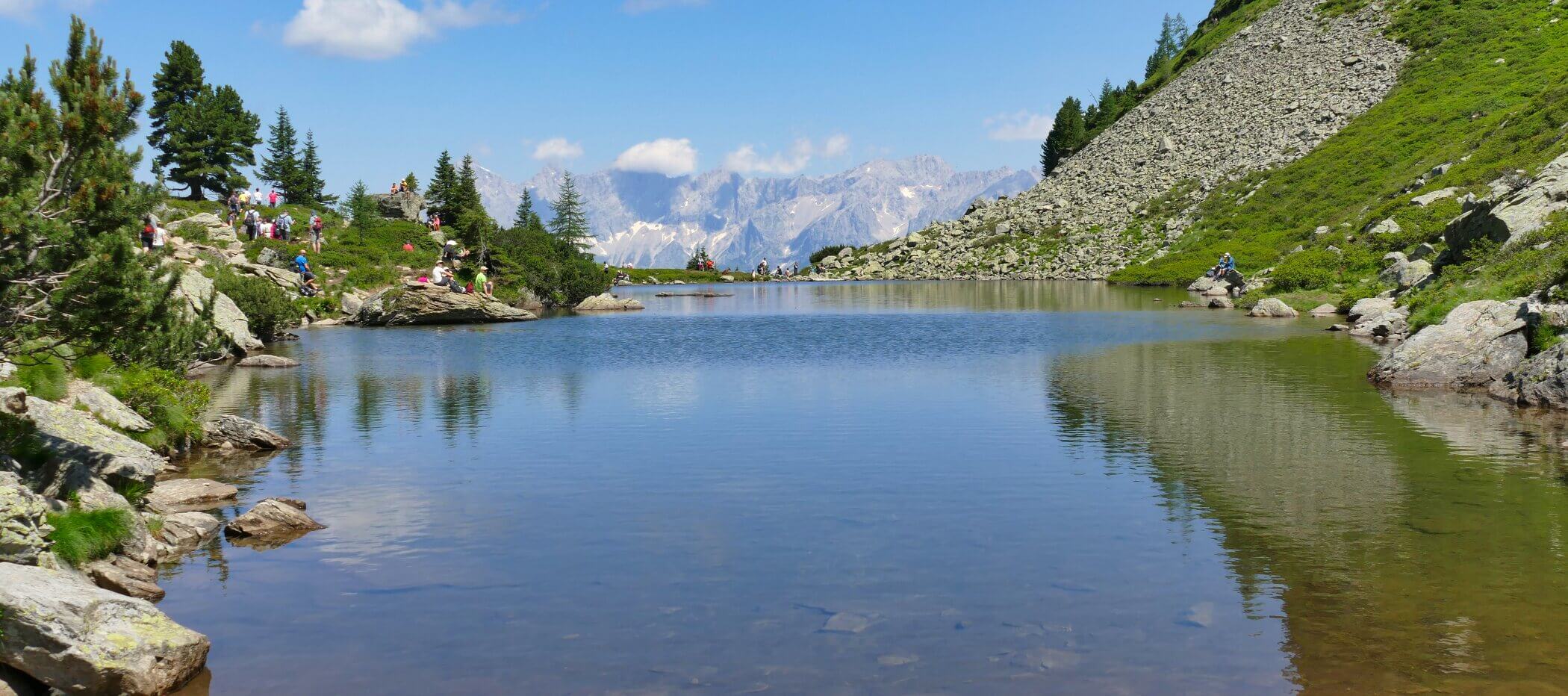 See mit Bergmassiv im Hintergrund