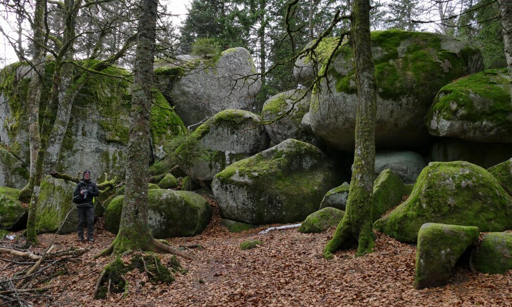 Kleiner Mann vor großen Felsen