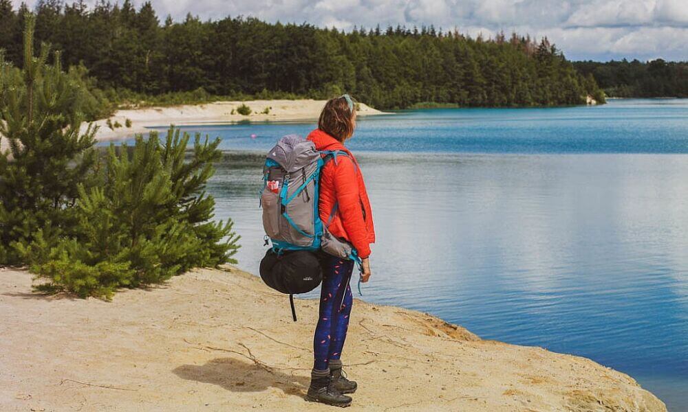 Frau mit Rucksack am See