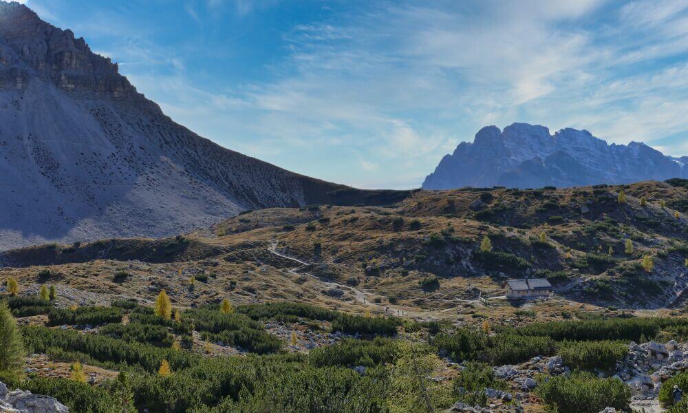 Alm mit Hütte und Bergen im Hintergrund