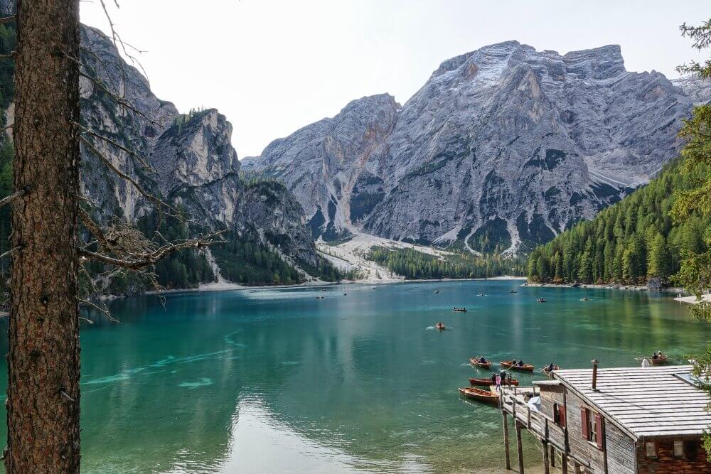 Bootshaus am See mit Bergkulisse im Hintergrund