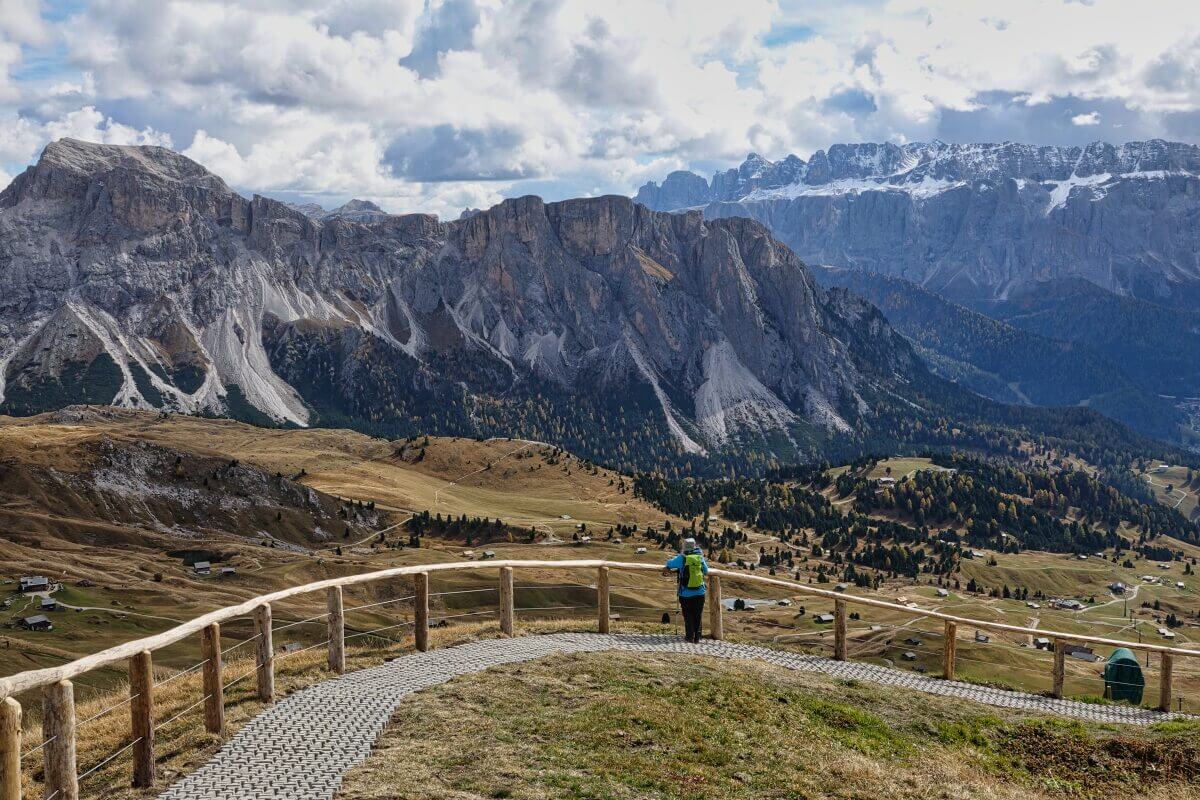 Frau steht auf Weg und schaut in die Berge