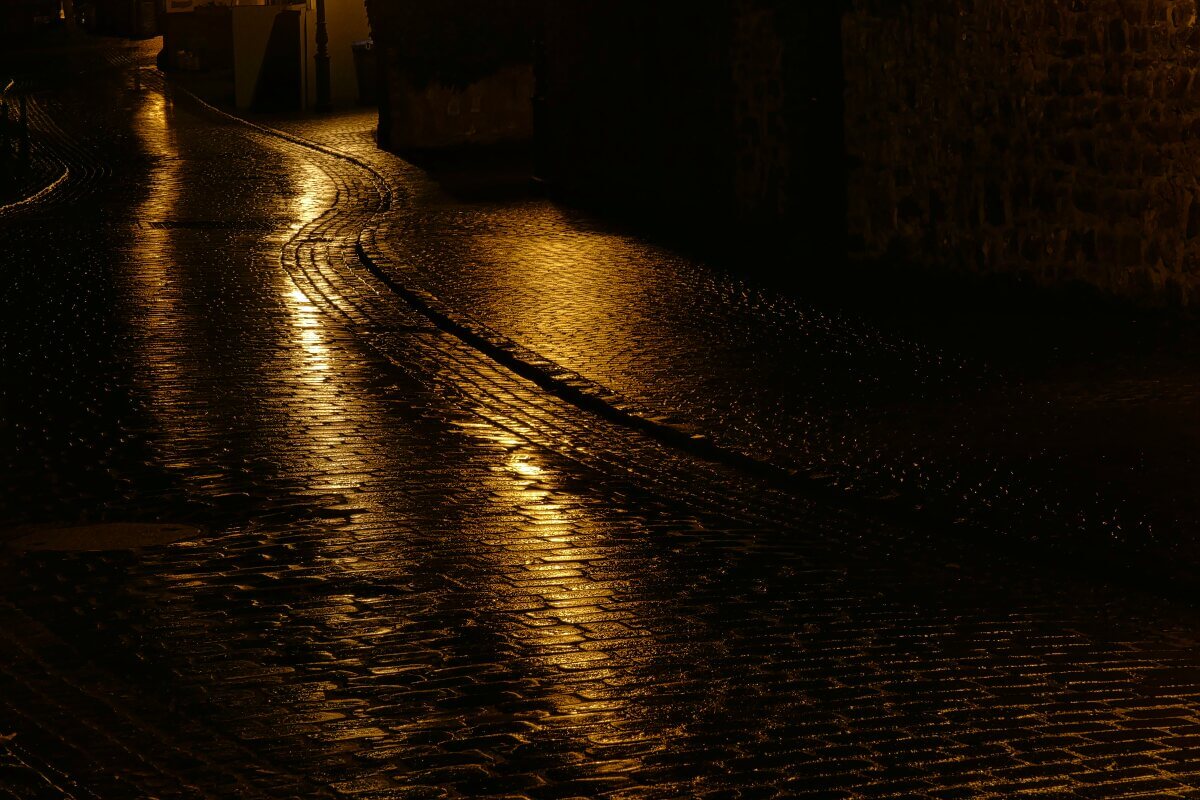 Straße bei Nacht mit Lichtreflexen