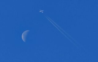 Flugzeug fliegt am Mond vorbei