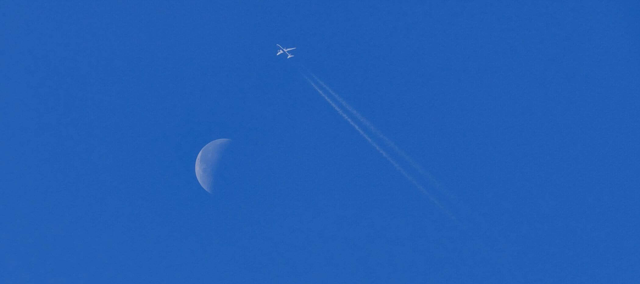 Flugzeug fliegt am Mond vorbei