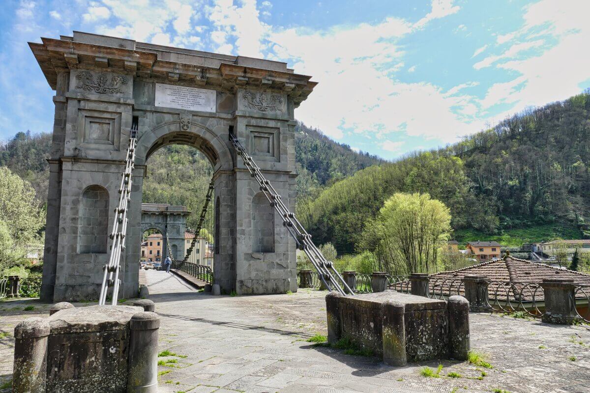 Wuchtige steinerne Brücke mit dicken Drahtseilen