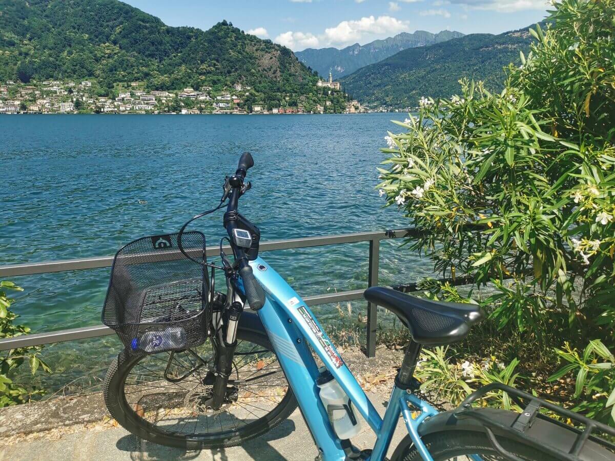 E-Bike am Seeufer mit Bergen im Hintergrund.