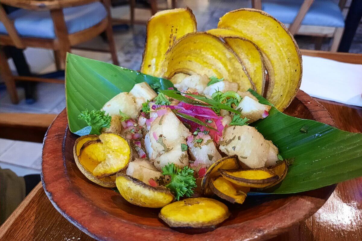Teller mit Kochbananen und Yucca, serviert auf Bananenblatt