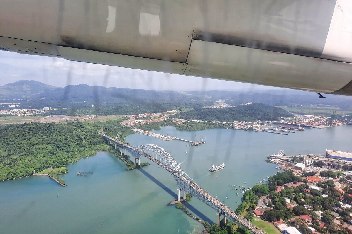 Blick aus Flugzeugfenster auf Kanal mit Brücke